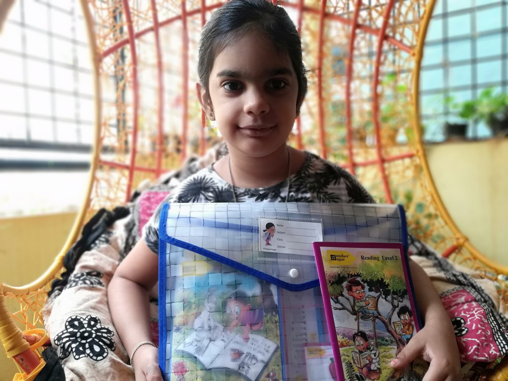 a girl holding a English Phonics learning kit